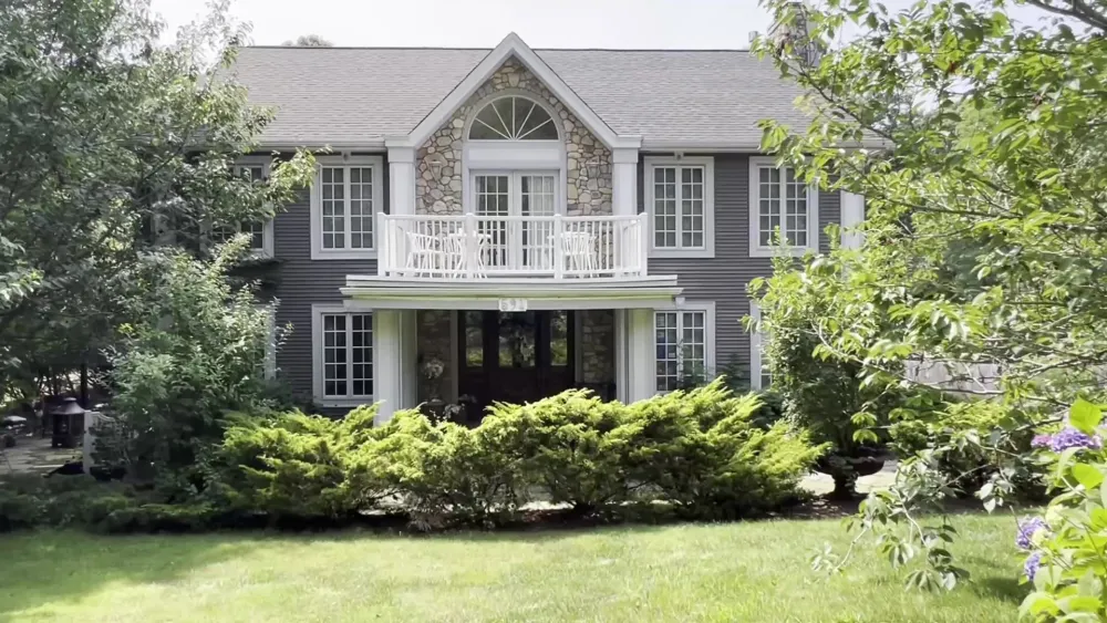 The front of Frederick William House with its second-floor balcony and garden