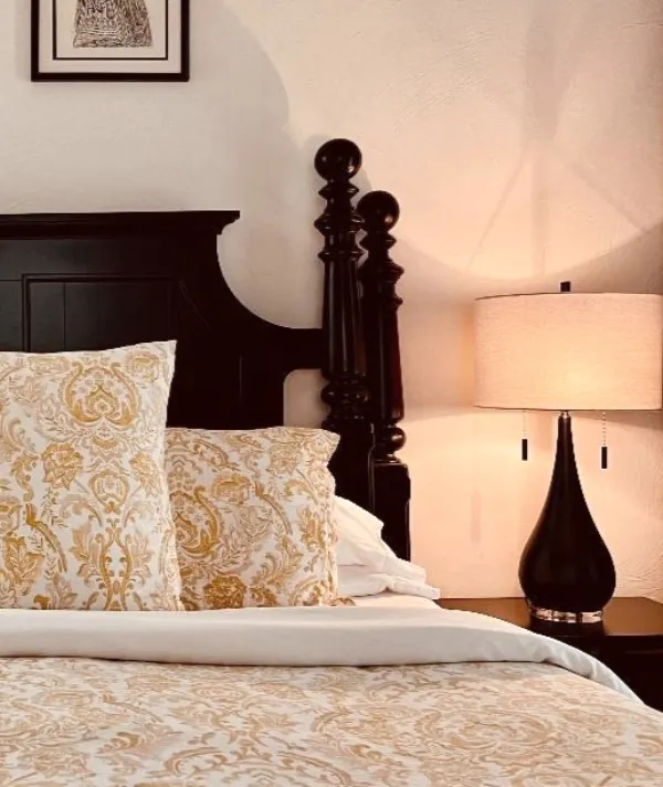 Guest room with a dark wood bed and warm lamp light